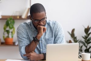 Head Shot Serious Puzzled African American Businessman Looking At Laptop - Notícias e Artigos Contábeis no Rio de Janeiro | Grupo Nova Cont